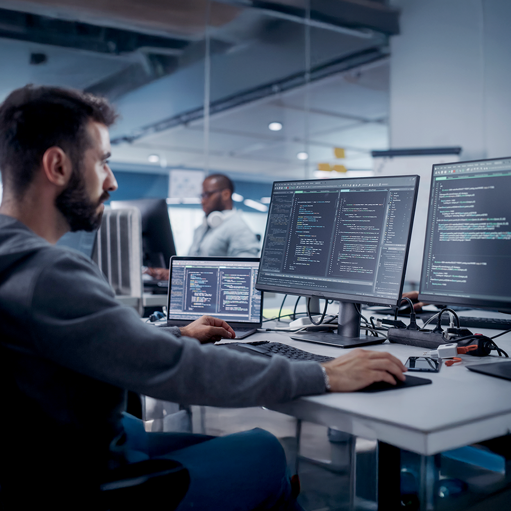 A man is working at computers in the office