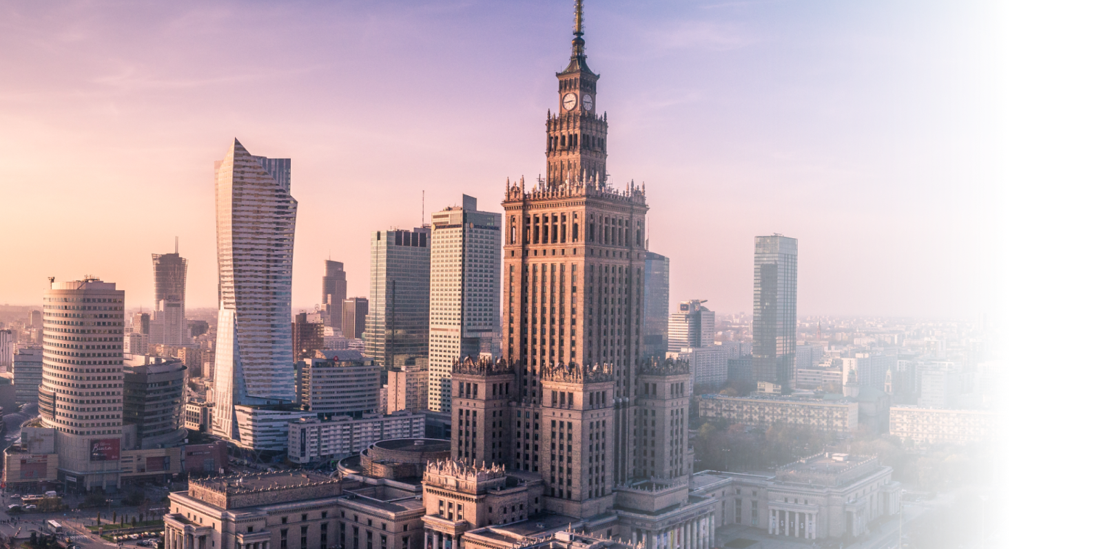 Warsaw city center at golden hour, featuring the Palace of Culture and Science alongside contemporary office towers