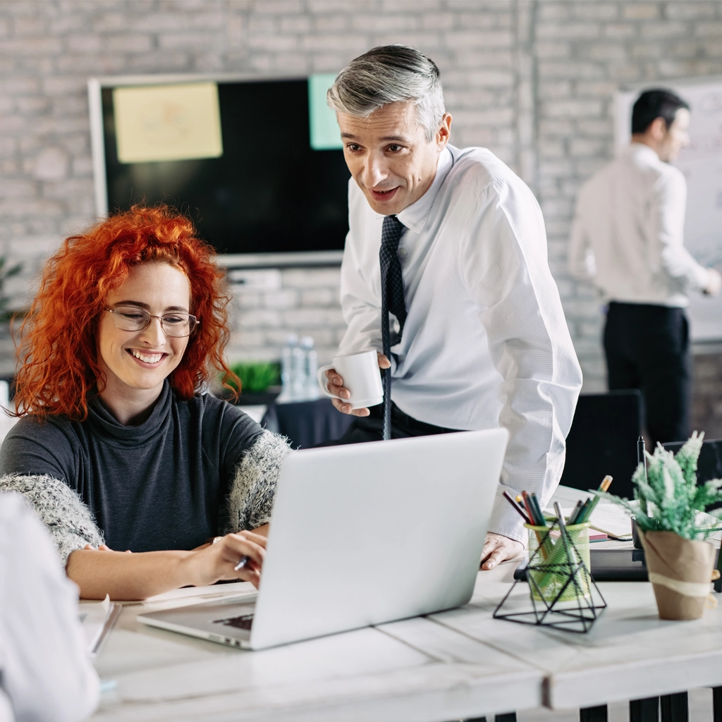 A woman and a man discussing a guide to offshore developer rates