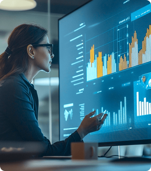 A woman is analyzing data on a big screen