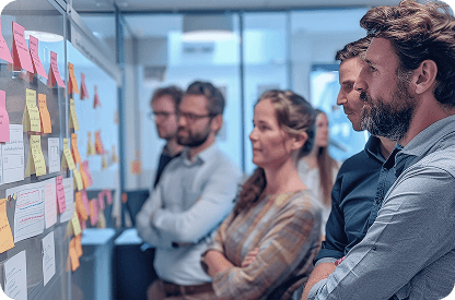 Men and women standing near a whiteboard and discussing software development improvements