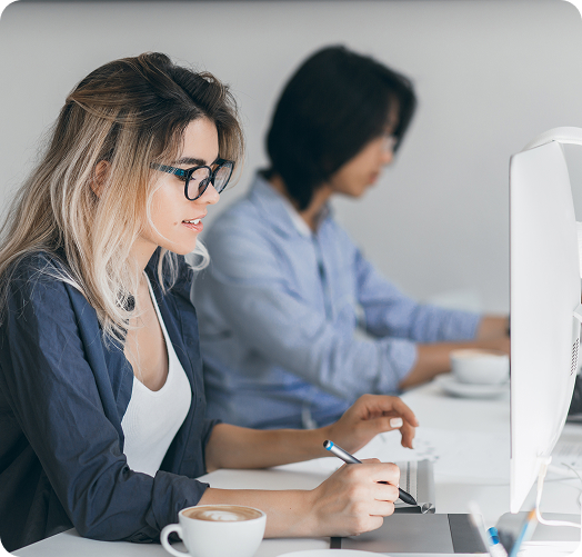 Two developers working at desktop computers in a modern office